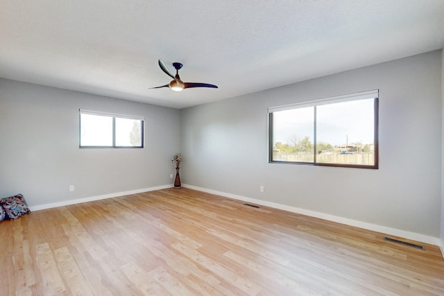 unfurnished room featuring a textured ceiling, light hardwood / wood-style floors, and ceiling fan