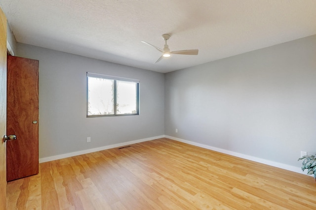 spare room with a textured ceiling, light hardwood / wood-style floors, and ceiling fan