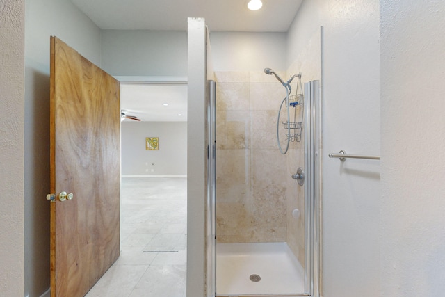 bathroom with tile patterned floors, ceiling fan, and a shower with shower door