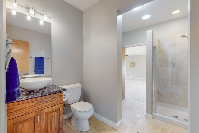 bathroom featuring toilet, vanity, tile patterned floors, and a shower with door