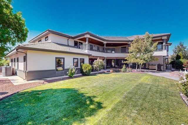 view of front of home featuring a front yard, a balcony, and a patio area