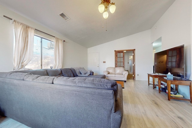 living room with light hardwood / wood-style flooring and vaulted ceiling