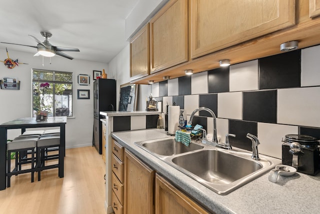 kitchen featuring light brown cabinets, light wood-type flooring, ceiling fan, and sink