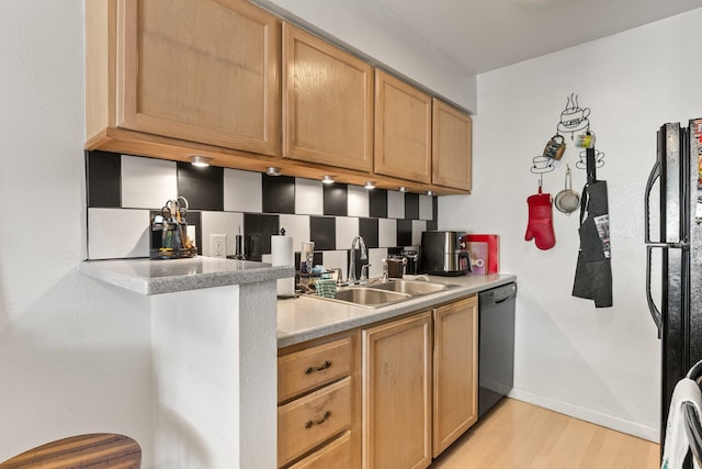 kitchen featuring light wood-type flooring, black dishwasher, tasteful backsplash, and sink