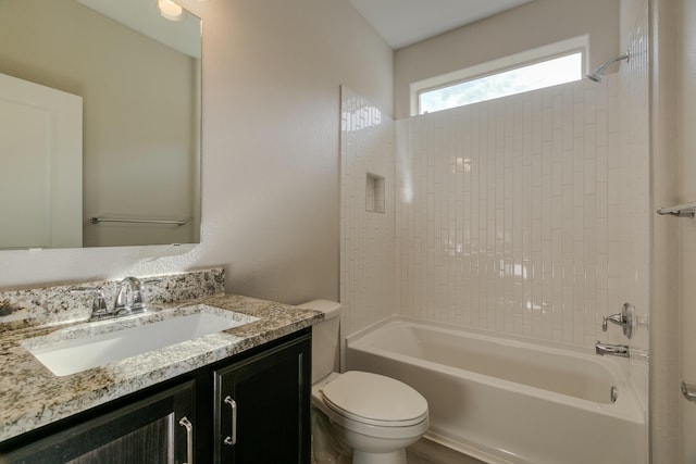 full bathroom featuring tiled shower / bath combo, toilet, and vanity