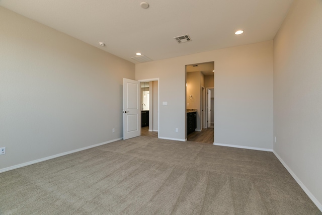 unfurnished bedroom with carpet flooring and connected bathroom