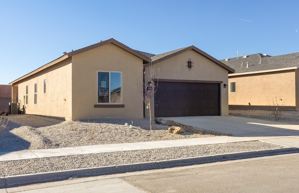 ranch-style home with cooling unit and a garage