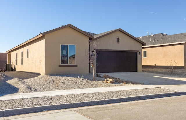 ranch-style home with cooling unit and a garage