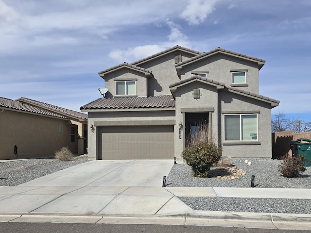 view of front facade with concrete driveway, a tile roof, an attached garage, and stucco siding