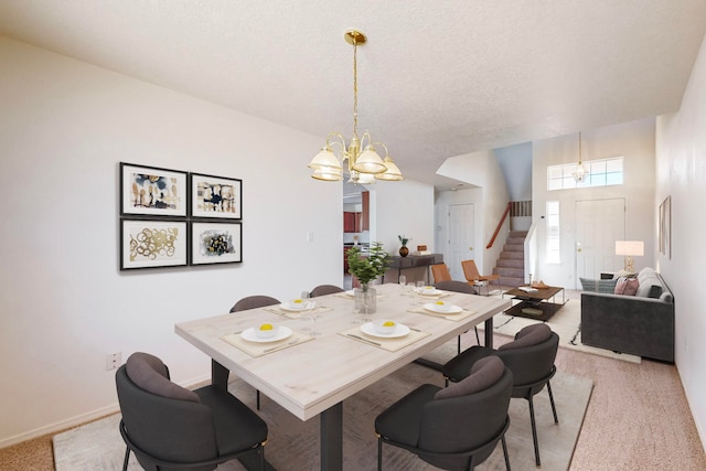 dining space featuring light carpet, a chandelier, and a textured ceiling