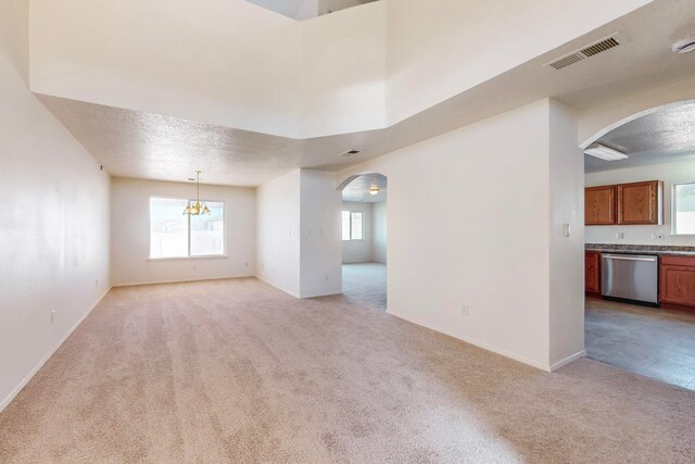 spare room featuring a textured ceiling and light carpet