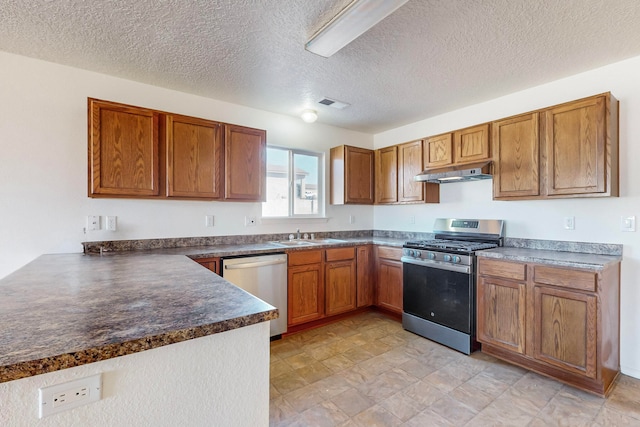 kitchen featuring kitchen peninsula, a textured ceiling, stainless steel appliances, and sink