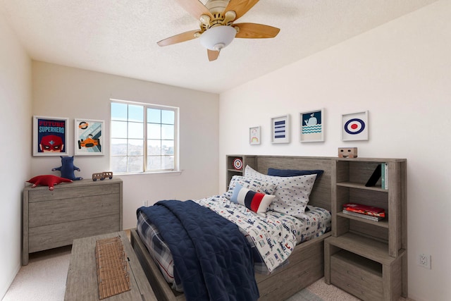 carpeted bedroom with ceiling fan and a textured ceiling