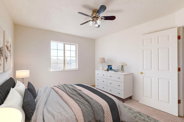 carpeted bedroom featuring a textured ceiling and ceiling fan