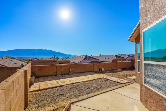 view of yard featuring a mountain view and a patio