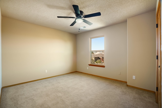 empty room featuring carpet flooring, ceiling fan, and a textured ceiling