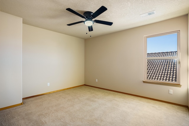 unfurnished room featuring a textured ceiling, light colored carpet, and ceiling fan