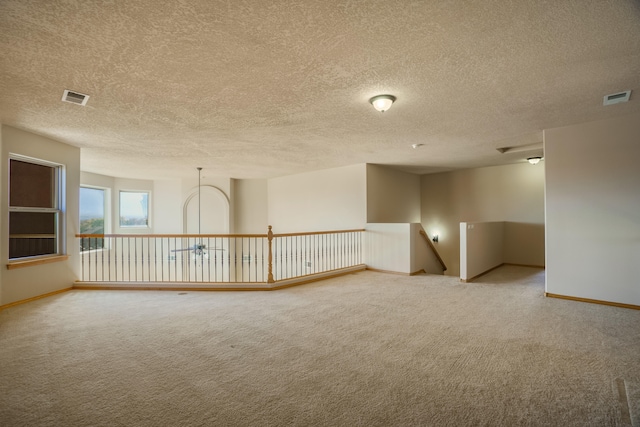 empty room featuring carpet and a textured ceiling