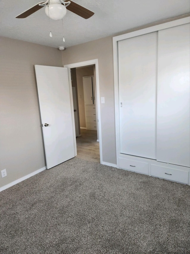 unfurnished bedroom with carpet flooring, ceiling fan, and a closet