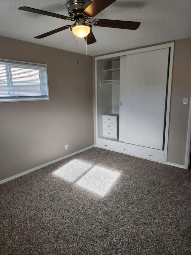 unfurnished bedroom featuring ceiling fan, a closet, and carpet