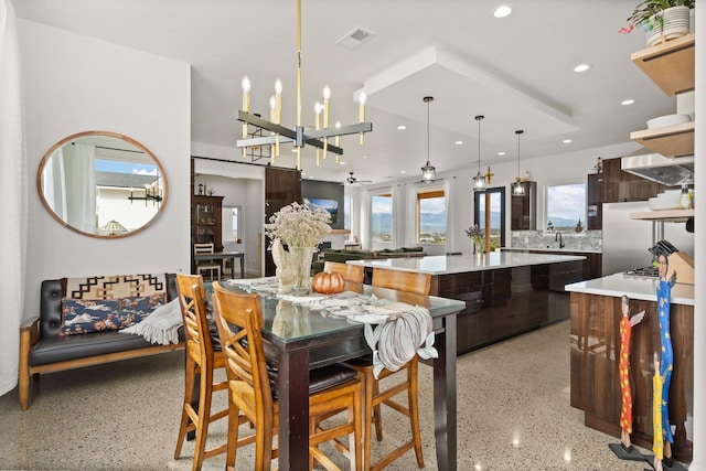 dining room with ceiling fan with notable chandelier