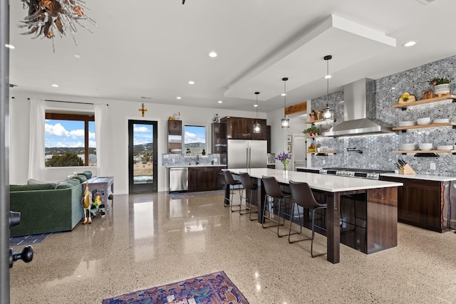 kitchen with dark brown cabinetry, extractor fan, appliances with stainless steel finishes, and tasteful backsplash