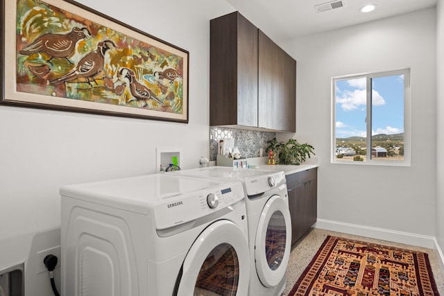 washroom featuring cabinets and washing machine and clothes dryer