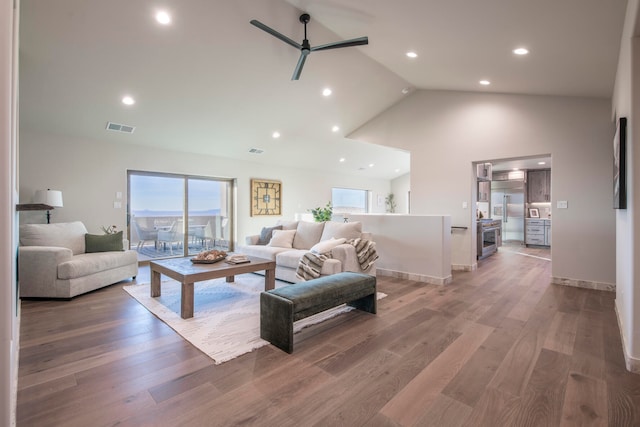 living room with hardwood / wood-style flooring, high vaulted ceiling, and ceiling fan