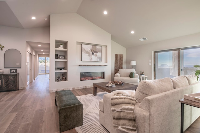 living room featuring high vaulted ceiling and hardwood / wood-style flooring