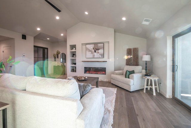 living room with hardwood / wood-style floors, built in shelves, and vaulted ceiling