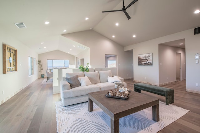 living room featuring ceiling fan, vaulted ceiling, and light wood-type flooring