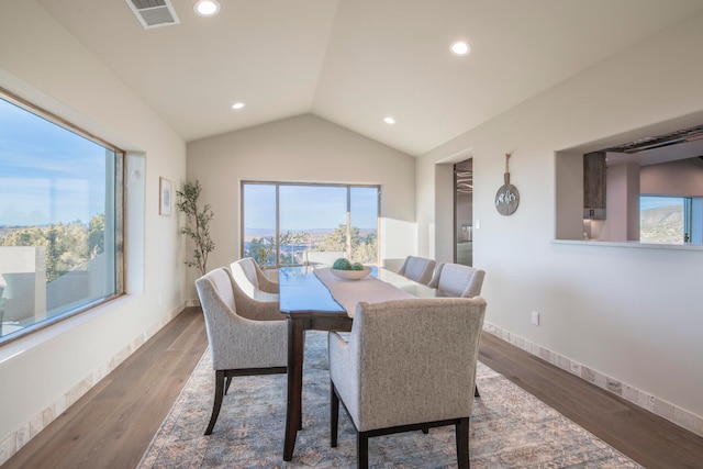 dining space with dark hardwood / wood-style flooring and lofted ceiling