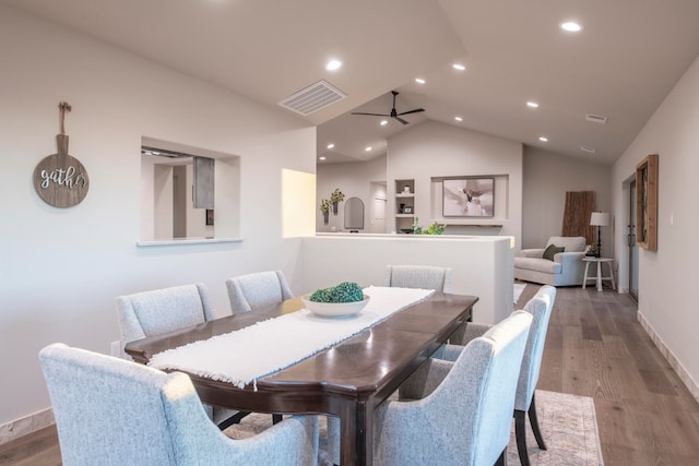 dining room featuring light wood-type flooring, vaulted ceiling, and ceiling fan