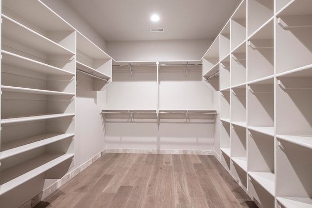 spacious closet with hardwood / wood-style flooring