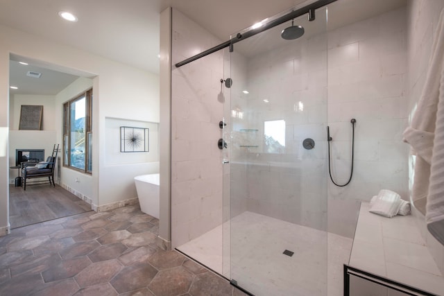 bathroom with shower with separate bathtub and hardwood / wood-style floors