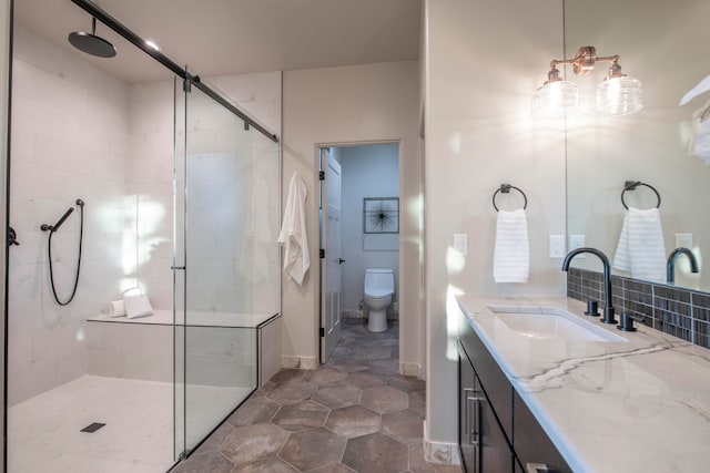 bathroom featuring tasteful backsplash, tile patterned floors, an enclosed shower, vanity, and toilet