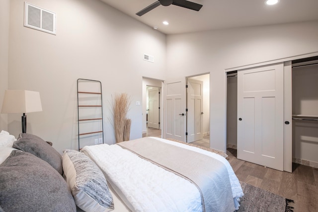 bedroom featuring ceiling fan, hardwood / wood-style floors, and high vaulted ceiling