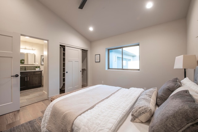 bedroom with ensuite bathroom, sink, ceiling fan, light hardwood / wood-style floors, and a closet