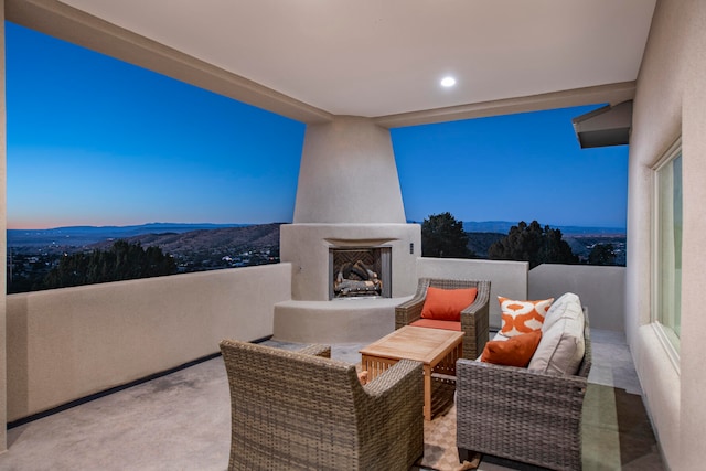 patio terrace at dusk with an outdoor fireplace