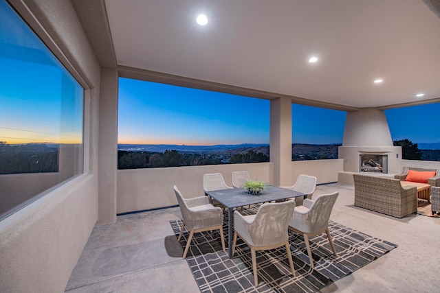 patio terrace at dusk with an outdoor living space with a fireplace