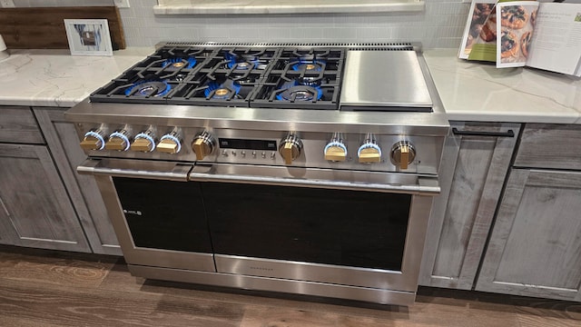 room details featuring decorative backsplash, dark brown cabinets, and double oven range