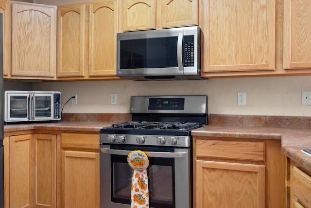 kitchen featuring light brown cabinets and appliances with stainless steel finishes