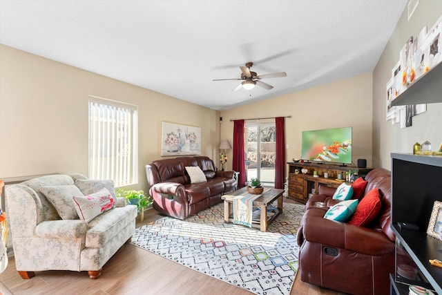 living room with ceiling fan, lofted ceiling, and light wood-type flooring