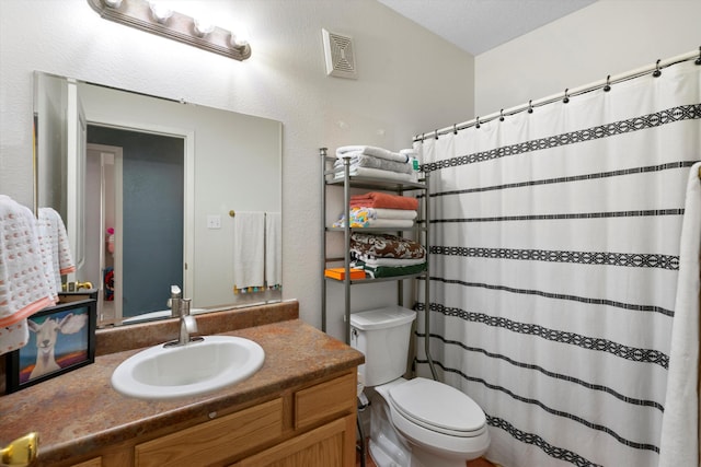 bathroom with vanity, a textured ceiling, and toilet