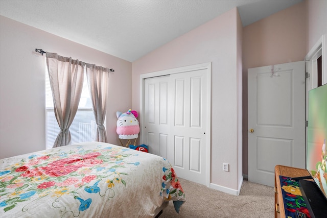 bedroom featuring a textured ceiling, light colored carpet, vaulted ceiling, and a closet