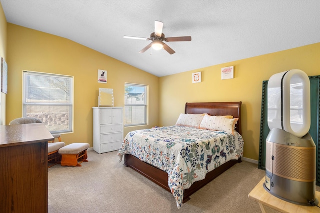 bedroom with a textured ceiling, ceiling fan, light carpet, and vaulted ceiling