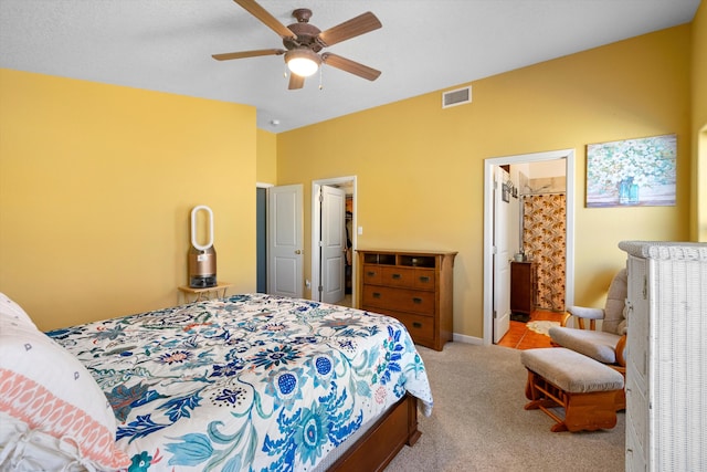 carpeted bedroom featuring ensuite bathroom and ceiling fan