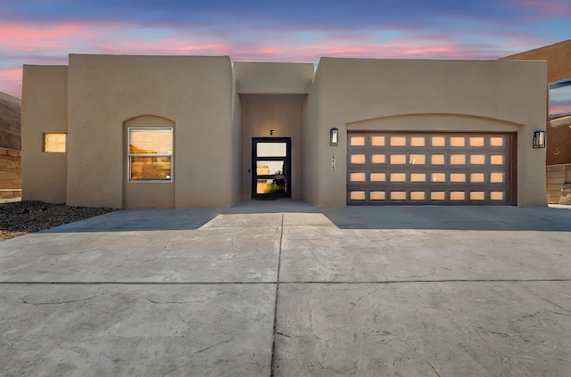 pueblo-style home featuring a garage