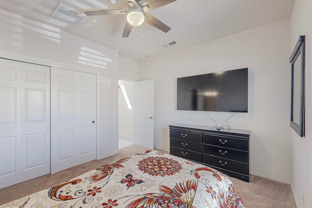 carpeted bedroom featuring ceiling fan and a closet