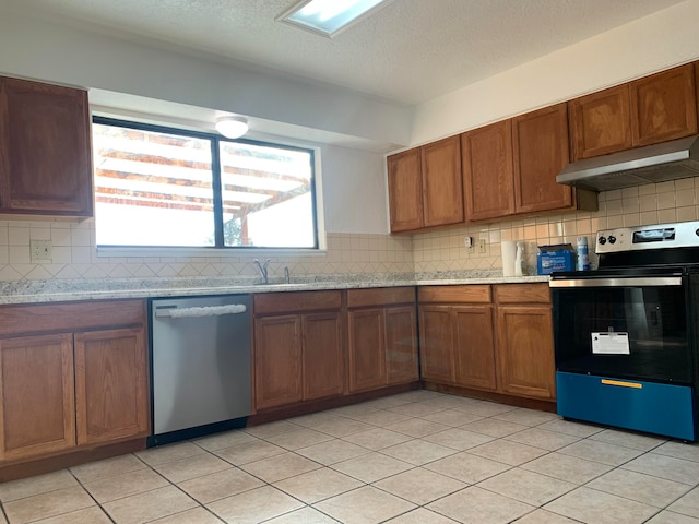 kitchen featuring appliances with stainless steel finishes, backsplash, light tile patterned floors, and sink